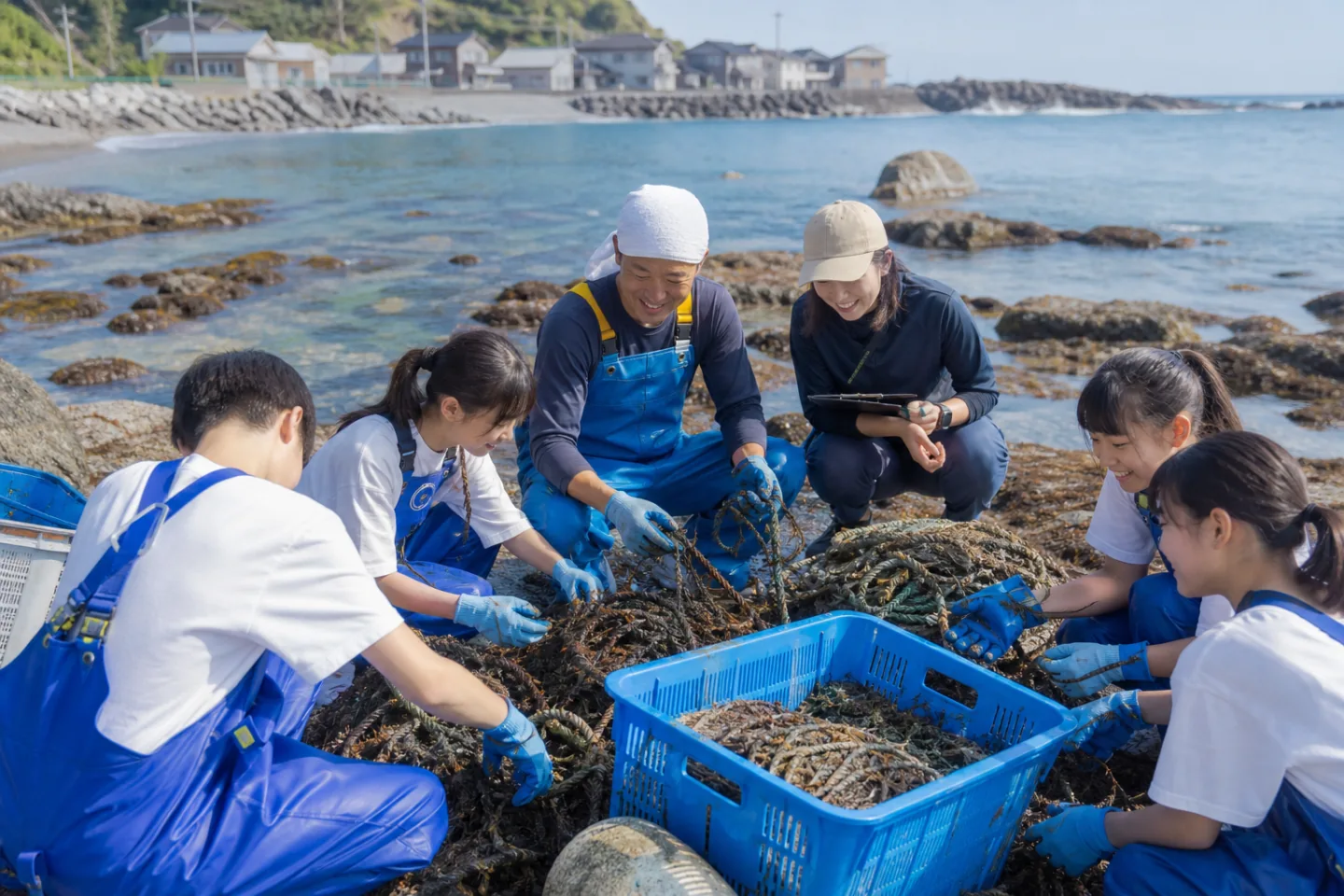日本の磯で漁具を回収し海洋環境を調査する漁業者と学生